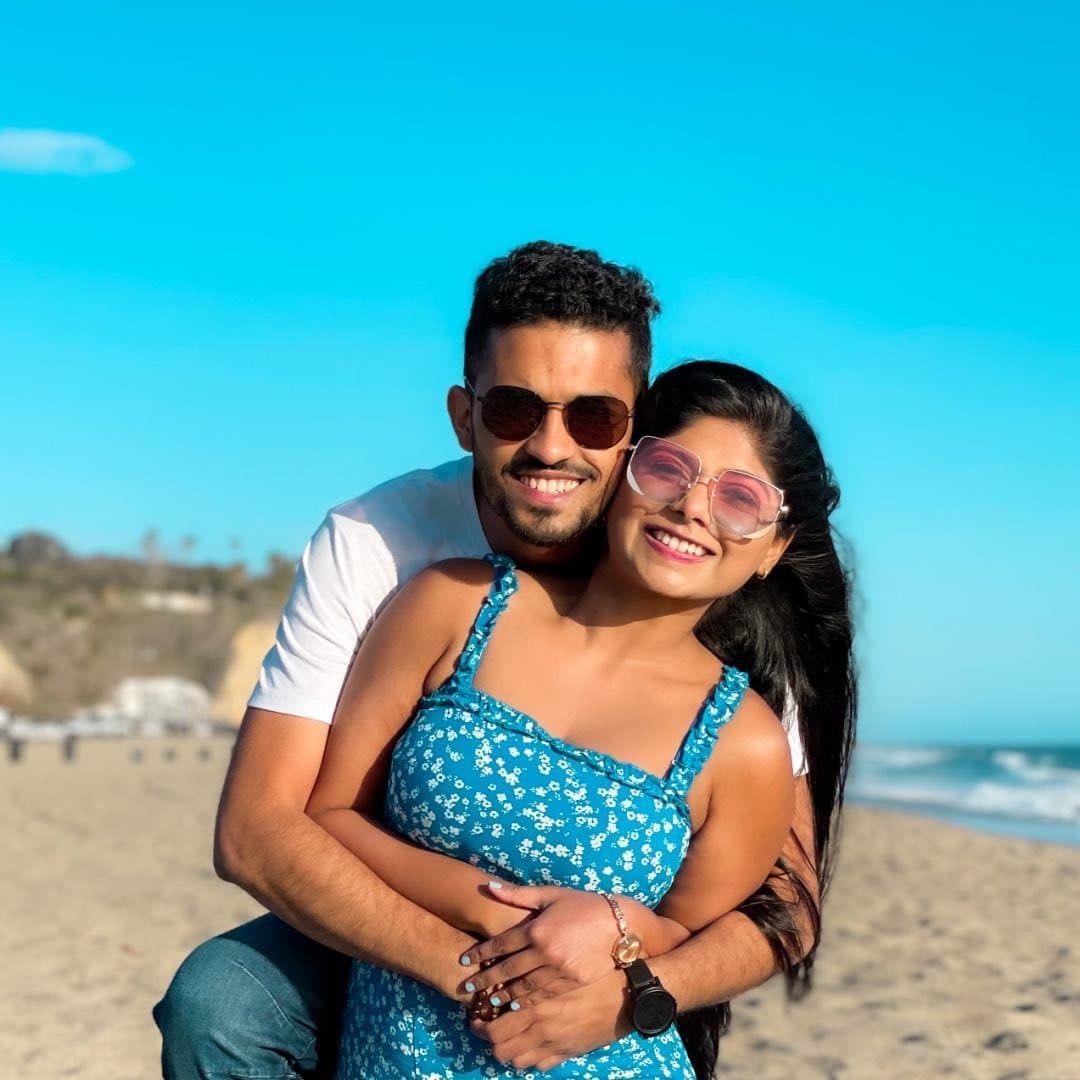 A man and woman hugging on the beach.